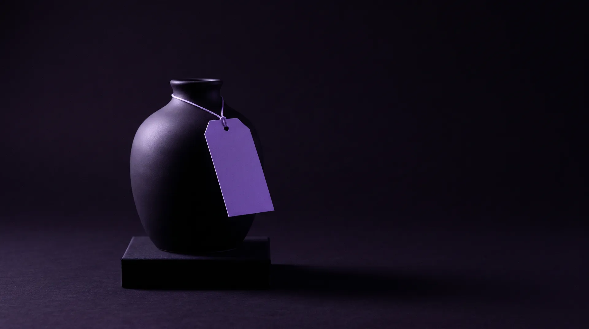 Keraaminen maljakko jalustalla ja violetti hintalappu narussa